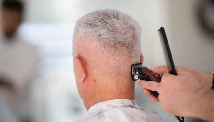 person using hair razor on man s hair